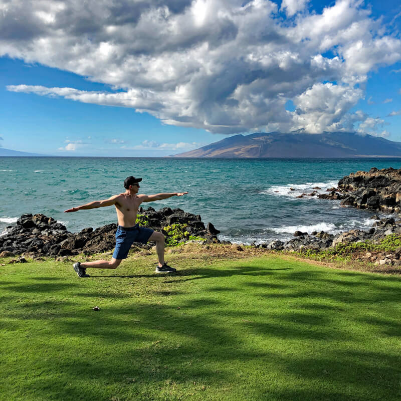 David doing a lunge by the ocean.