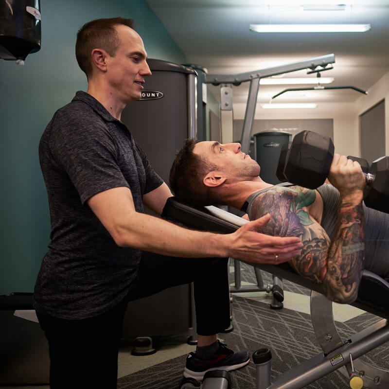 David spots client lifting weights